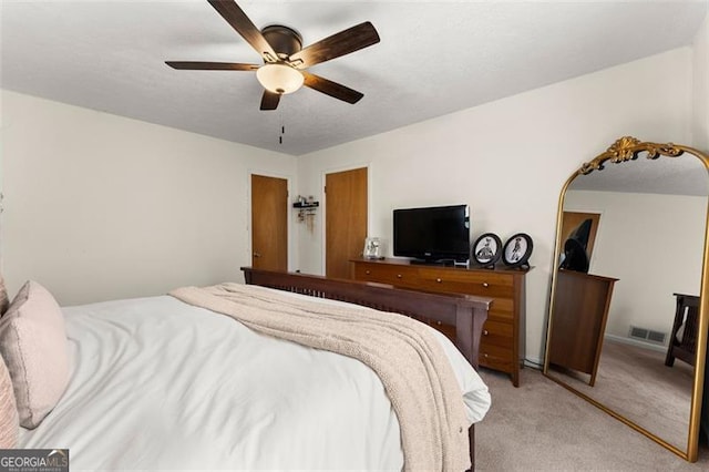 bedroom with visible vents, light carpet, arched walkways, and a ceiling fan