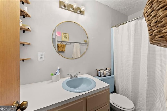 full bathroom featuring toilet, curtained shower, a textured ceiling, and vanity