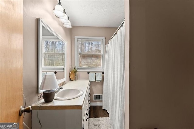 full bath with visible vents, a textured ceiling, vanity, and a shower with curtain