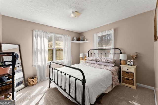 bedroom with baseboards, carpet floors, and a textured ceiling