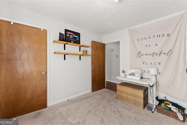 unfurnished bedroom with carpet, baseboards, and a textured ceiling