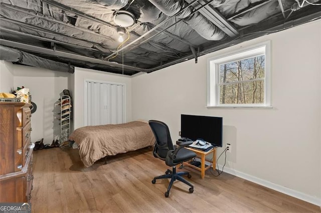 bedroom featuring a closet, baseboards, and wood finished floors