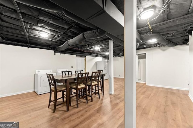 finished basement featuring washer and dryer, wood finished floors, and baseboards