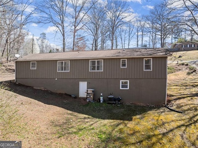 view of side of property with a yard and central AC