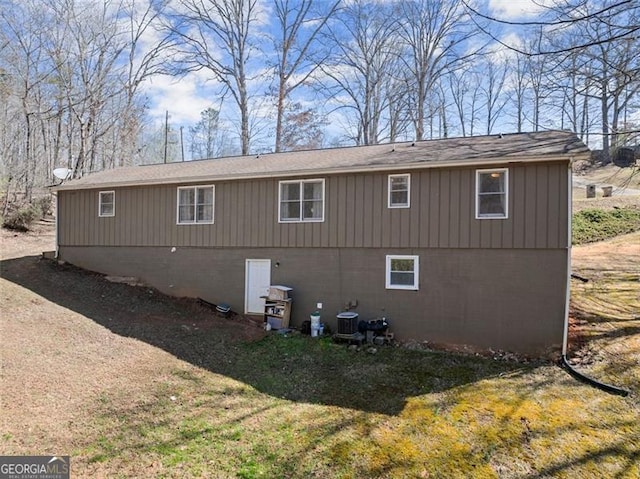 view of side of property featuring central air condition unit and a yard