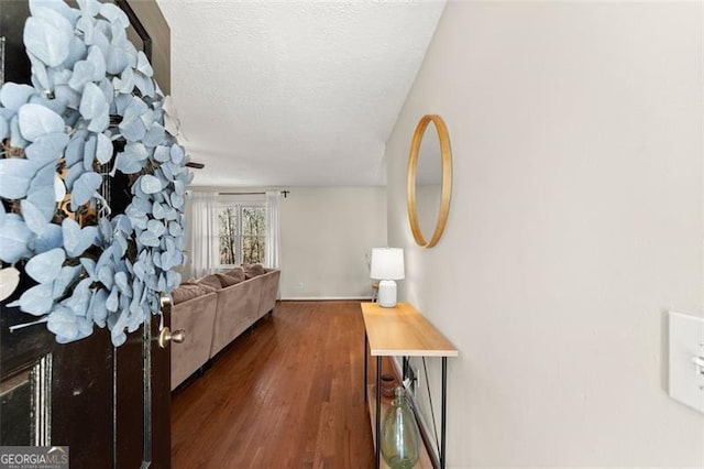 hall featuring a textured ceiling and wood finished floors