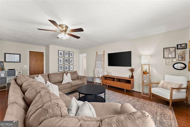 living area with a textured ceiling, a ceiling fan, and wood finished floors