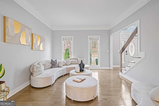 living room featuring baseboards, wood finished floors, stairs, and crown molding