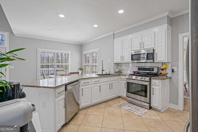 kitchen featuring a sink, a peninsula, white cabinets, and stainless steel appliances