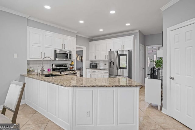 kitchen with light stone countertops, stainless steel appliances, a peninsula, and a sink