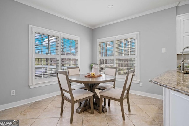 dining area featuring light tile patterned floors, baseboards, and ornamental molding