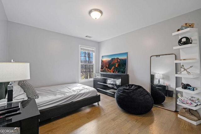 bedroom with visible vents and wood finished floors