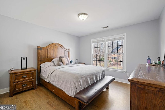 bedroom with visible vents, baseboards, and light wood finished floors