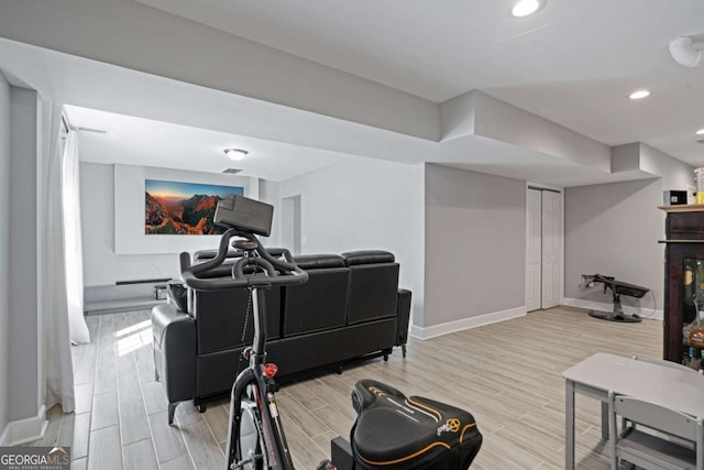 workout room featuring recessed lighting, baseboards, and wood finish floors