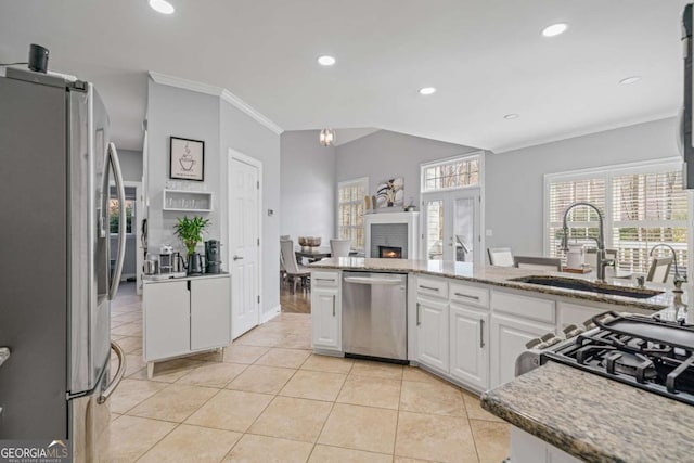 kitchen featuring a sink, appliances with stainless steel finishes, white cabinets, light tile patterned flooring, and crown molding