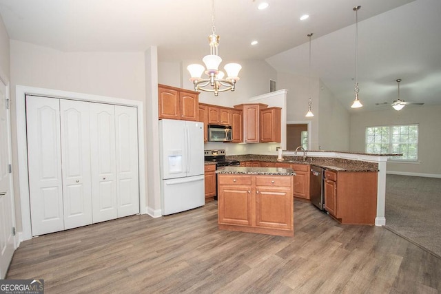 kitchen featuring a sink, a peninsula, light wood finished floors, and stainless steel appliances