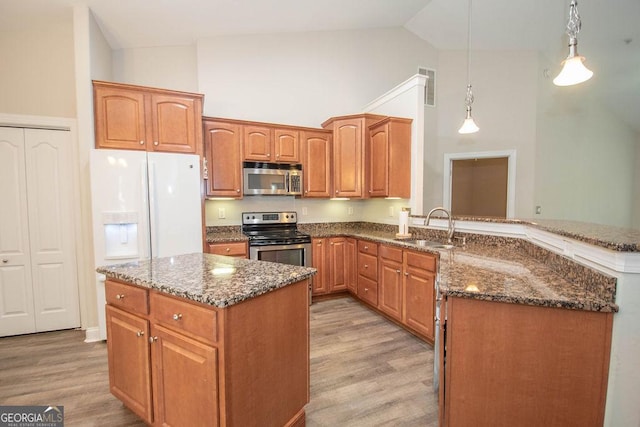 kitchen featuring light wood-type flooring, visible vents, a sink, stainless steel appliances, and dark stone counters