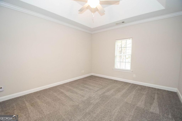 carpeted spare room featuring visible vents, a ceiling fan, crown molding, and baseboards