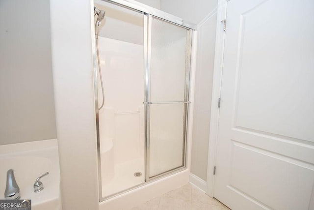 full bathroom featuring a shower stall, a tub to relax in, and tile patterned floors