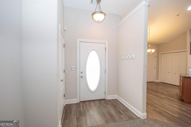 entryway featuring a notable chandelier, baseboards, and wood finished floors