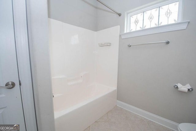 bathroom with tile patterned flooring, tub / shower combination, and baseboards