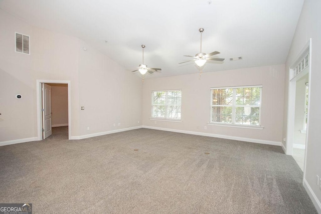 spare room with visible vents, carpet floors, high vaulted ceiling, and baseboards