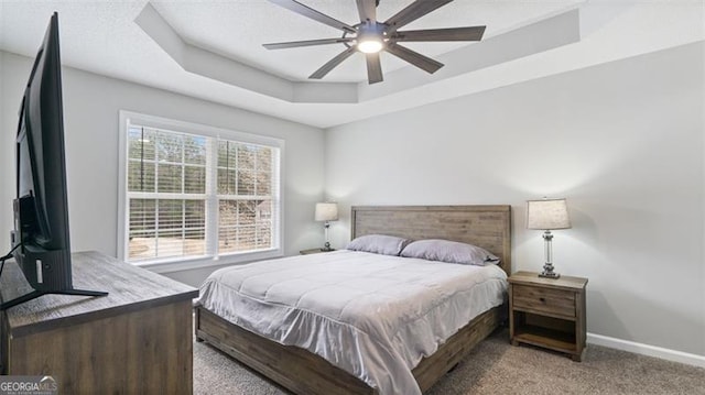 bedroom featuring baseboards, a raised ceiling, carpet floors, and ceiling fan