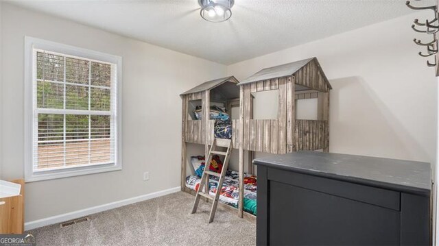 carpeted bedroom with visible vents and baseboards