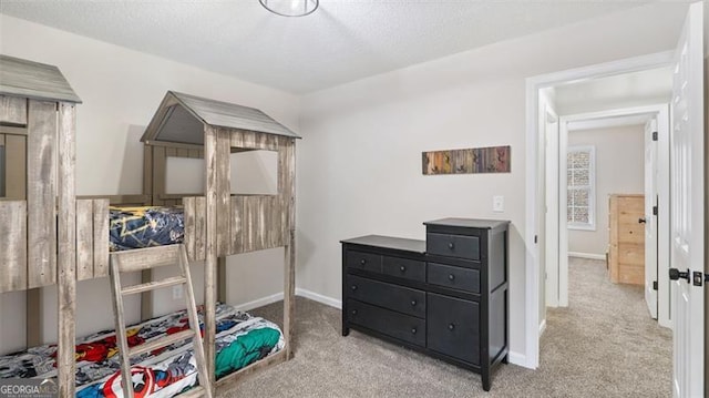 bedroom with baseboards, a textured ceiling, and carpet flooring