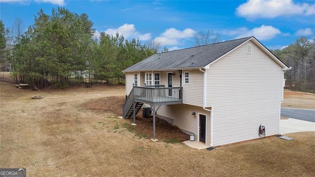 view of side of home featuring stairway and a wooden deck