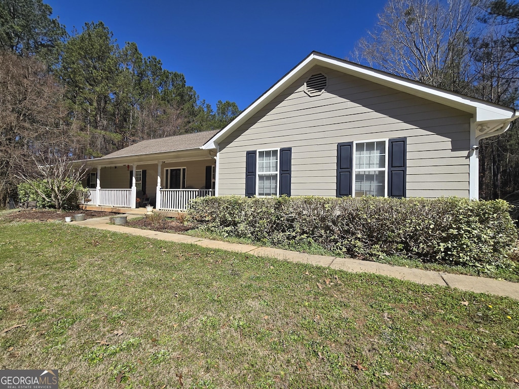 single story home with covered porch and a front yard