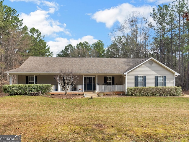 ranch-style home featuring covered porch and a front lawn