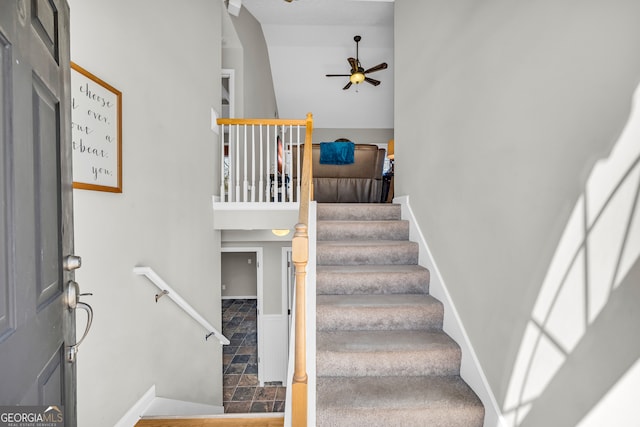 staircase with stone finish floor, baseboards, and a ceiling fan