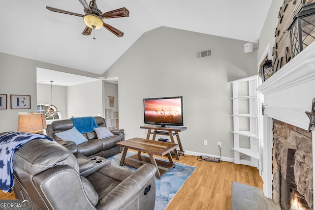 living area with visible vents, a fireplace, light wood finished floors, baseboards, and ceiling fan