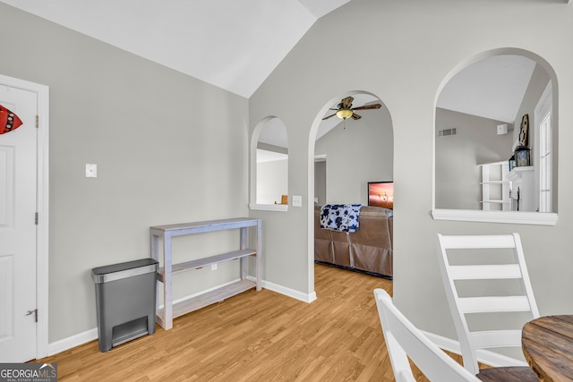 interior space featuring visible vents, ceiling fan, baseboards, lofted ceiling, and wood finished floors