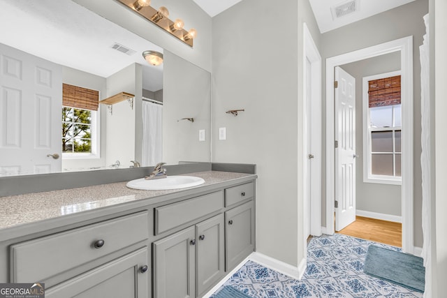 bathroom with visible vents, vanity, and baseboards