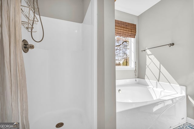 full bathroom featuring a bath and a stall shower