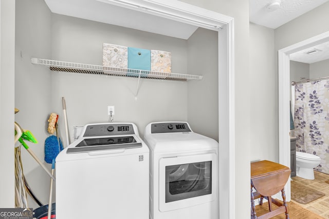 washroom featuring laundry area, separate washer and dryer, and light wood-style floors