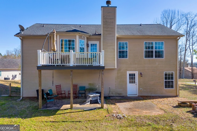 back of property featuring a patio area, a chimney, and a yard