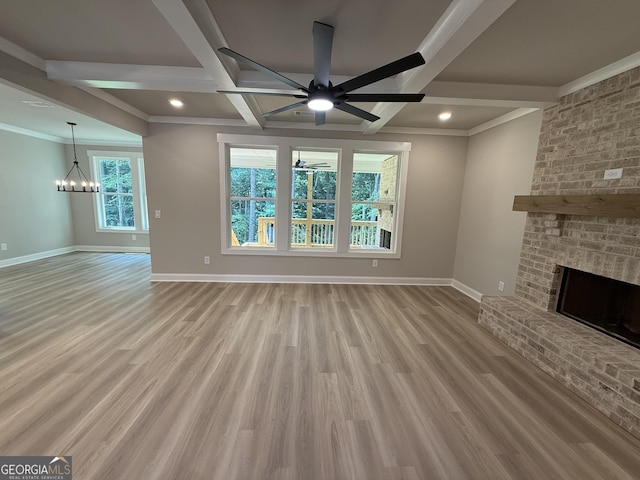73 Hewett Rd, Pendergrass, GA 30567 - unfurnished living room featuring ceiling fan, baseboards, a brick fireplace, wood finished floors, and a chandelier