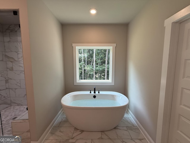 73 Hewett Rd, Pendergrass, GA 30567 - bathroom with marble look tiles, baseboards, a freestanding tub, a shower stall, and recessed lighting