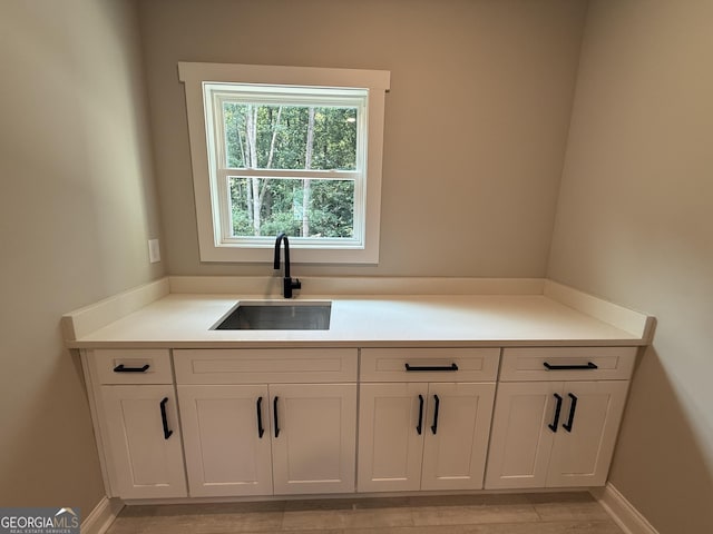 73 Hewett Rd, Pendergrass, GA 30567 - kitchen featuring a sink, white cabinets, light countertops, and baseboards