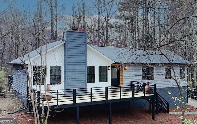 view of side of property with a chimney and a deck