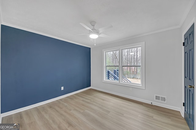 unfurnished bedroom featuring baseboards, wood finished floors, visible vents, and ornamental molding