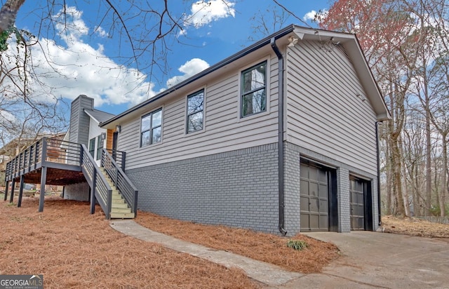 137 Creekview Dr, Woodstock, GA 30188 - view of side of property with stairway, a garage, brick siding, driveway, and a wooden deck