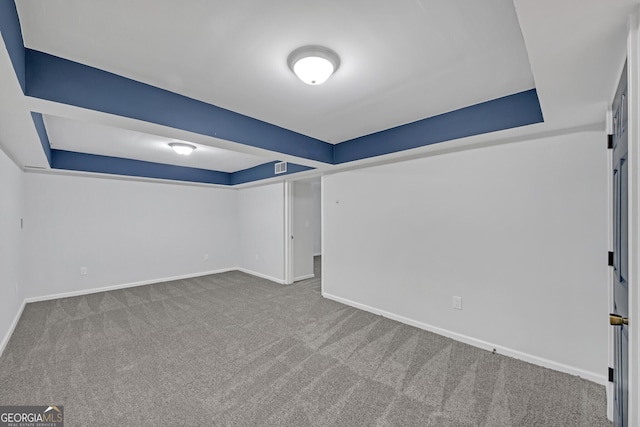 interior space with a raised ceiling, carpet, and baseboards