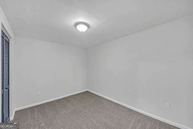 carpeted spare room featuring baseboards