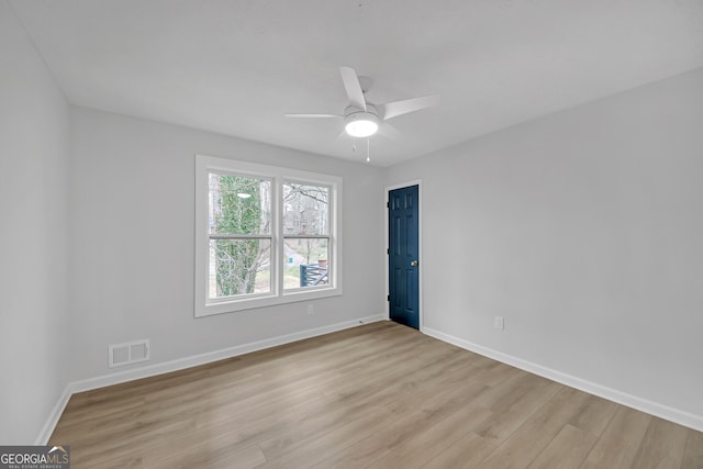 empty room with a ceiling fan, light wood-style floors, visible vents, and baseboards