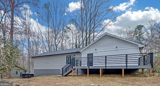 rear view of property featuring a deck and stairway