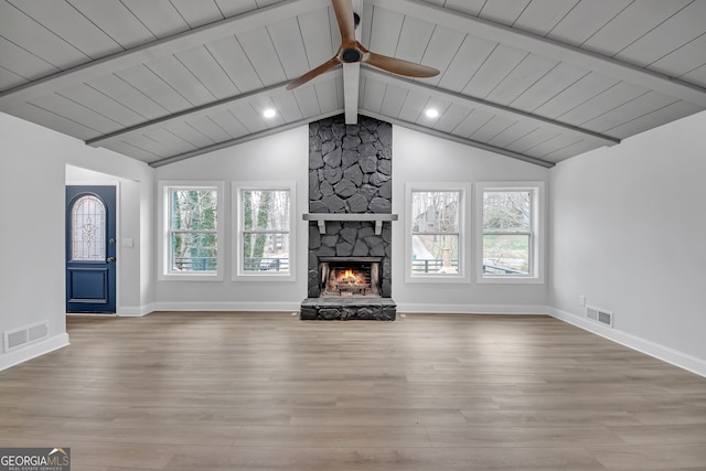 unfurnished living room with ceiling fan, visible vents, wood finished floors, and vaulted ceiling with beams